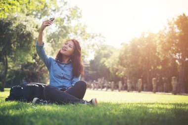 Selfie, otururken ona telefon alarak genç hipster kadın 