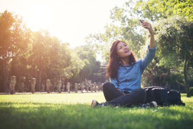 Selfie, otururken ona telefon alarak genç hipster kadın 