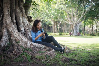 Yeşil p otururken ona telefon yazarak genç hipster kadın