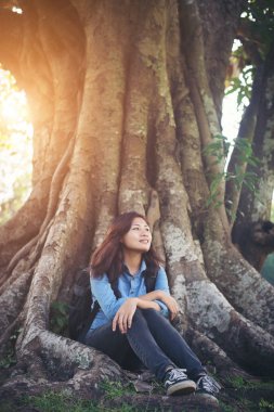 Yeşil park adlı oturan genç hipster kadın. Doğa sur ile keyfini çıkarın