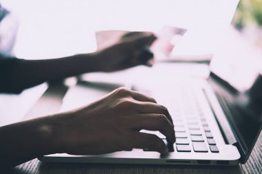 Kredi kartı tutan ve dizüstü bilgisayar kullanarak eller kadın. Online shoppin