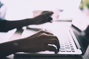 Kredi kartı tutan ve dizüstü bilgisayar kullanarak eller kadın. Online shoppin