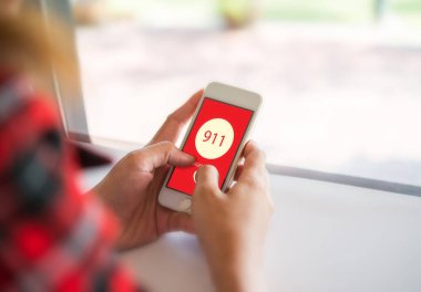 Ekranda acil durum numarası çevirmeden bir smartphone tutan kadın. G