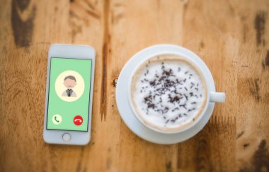 Gelen aramayı baba içinde hareket eden telefon. Bir fincan ile Üstten Görünüm