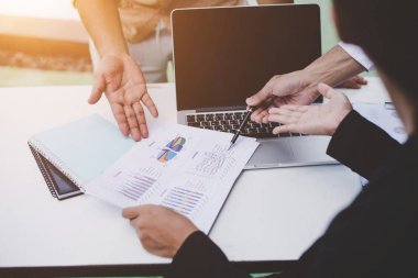 İş ortakları toplantıda belge ve fikirleri tartışıyor.