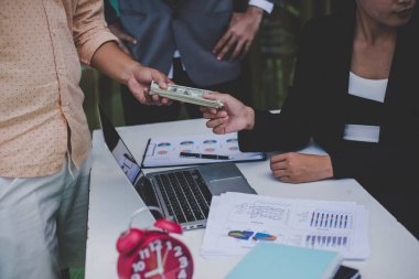 İş ortakları belgeleri ve fikirler toplantısında tartışıyor. Ben