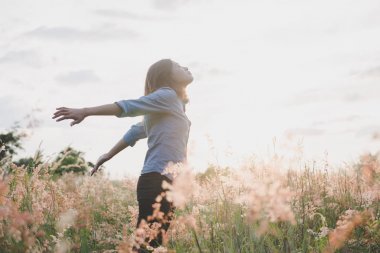 Duran genç güzel kadın inci üzerinde havada kollarını uzat