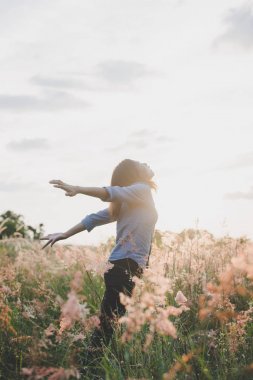 Duran genç güzel kadın inci üzerinde havada kollarını uzat