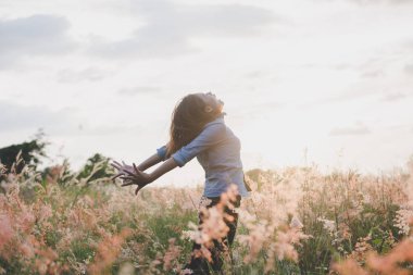 Duran genç güzel kadın inci üzerinde havada kollarını uzat