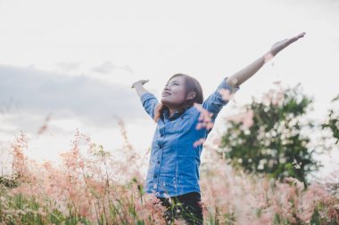 Duran genç güzel kadın inci üzerinde havada kollarını uzat