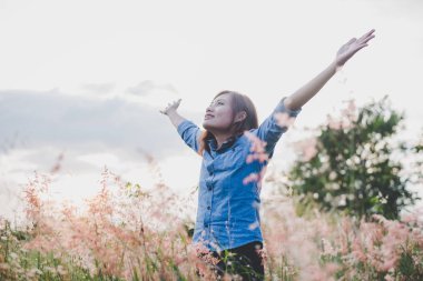 Duran genç güzel kadın inci üzerinde havada kollarını uzat