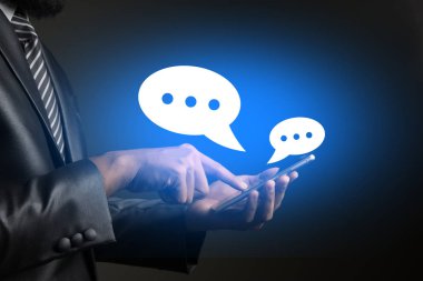 Konuşma balonları ile ayakta bir smartphone kullanarak iş adamı