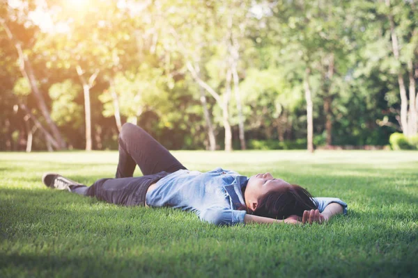 Schöne junge Hipster-Frau liegend und entspannend auf dem grünen Gr — Stockfoto