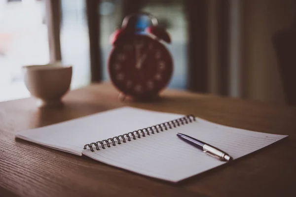 Mesa de escritorio vintage con cuadernos, bolígrafo y una taza de café — Foto de Stock