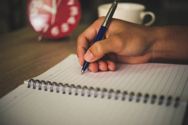 Mano del hombre con la escritura de la pluma en cuaderno . — Foto de Stock