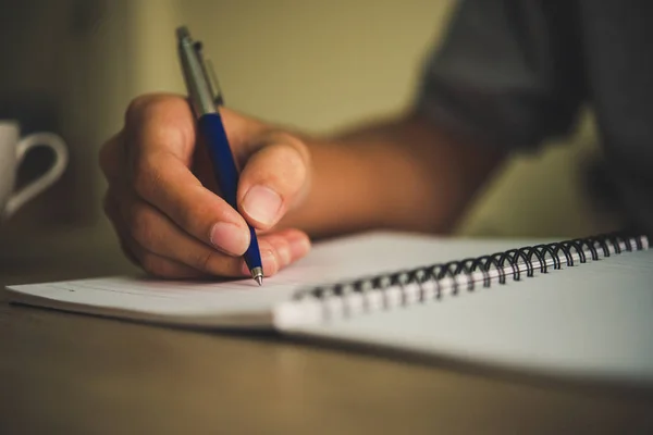 Man hand med penna skriva på anteckningsbok. — Stockfoto