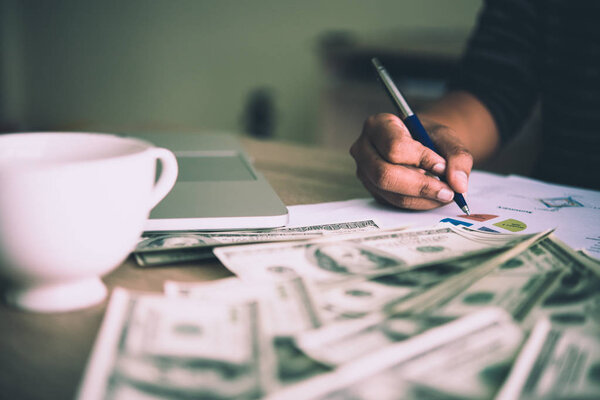 Working place of trader. The table covered by cash notes, keyboa