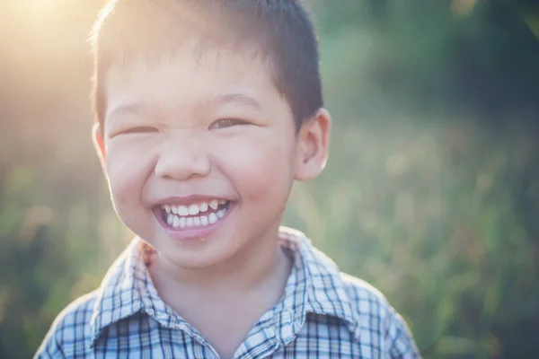 Primer plano de lindo chico asiático jugando y sonriendo al aire libre. Lindo li —  Fotos de Stock