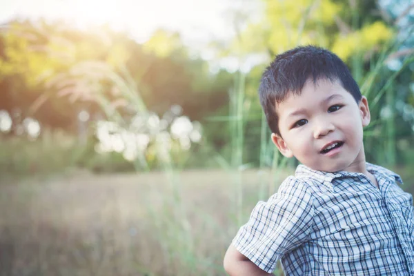Primer plano de lindo chico asiático jugando y sonriendo al aire libre. Lindo li —  Fotos de Stock