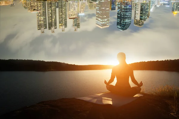 Silhouette of healthy woman is practicing yoga at mountain lake — Stock Photo, Image