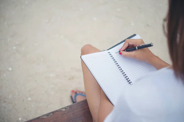 Primer plano de la escritura manual de la mujer en el bloc de notas . — Foto de Stock