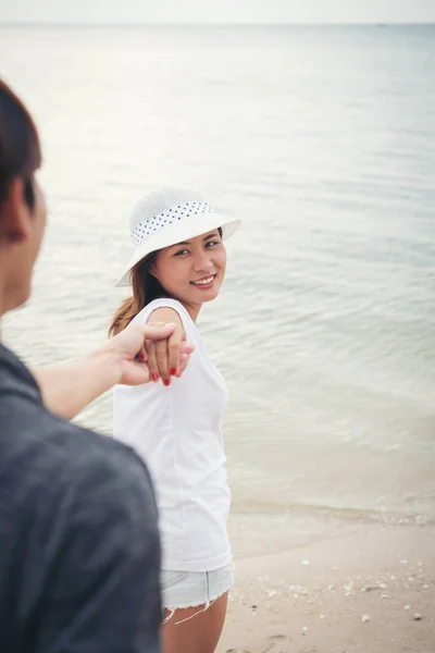Flickvän ta sin pojkvänner till stranden. Kvinna som håller hans m — Stockfoto