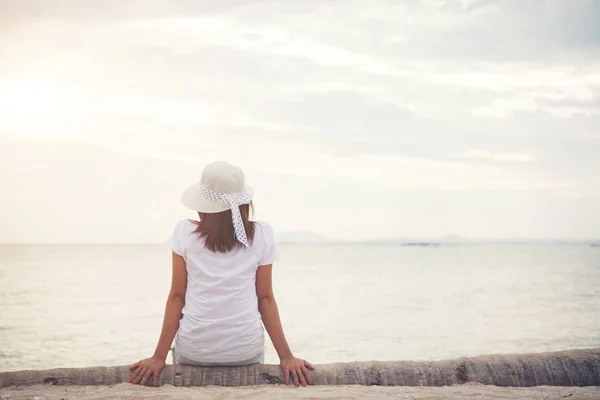 Rear of young woman sit on dead wood on the beach. Freedom enjoy — Stock Photo, Image