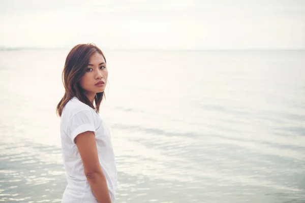 Junge Frau steht am Strand. — Stockfoto