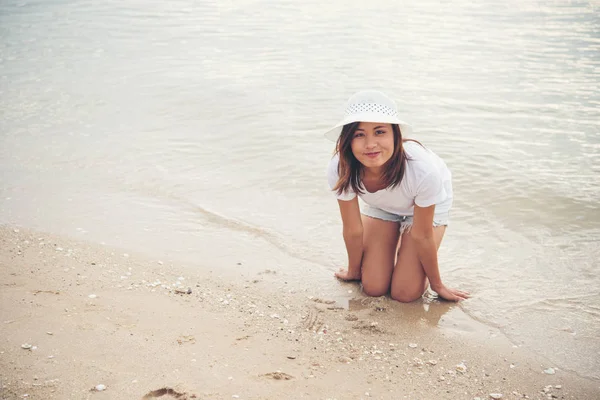 Gelukkig jonge vrouw spelen op het strand op de vakantietijd. — Stockfoto