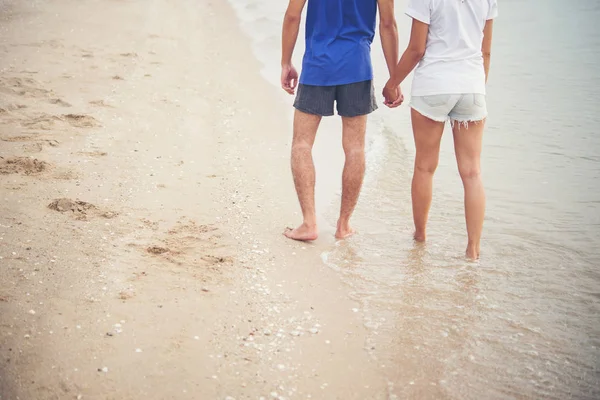 Genç çift yalınayak ile Sahilde yürüyüş arkası. — Stok fotoğraf