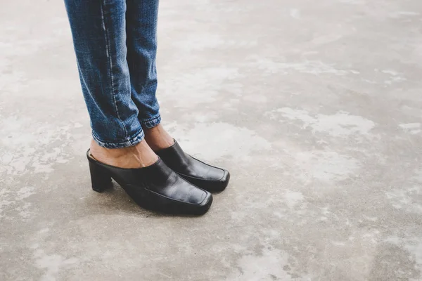Женские ноги в джинсовых брюках черные стильные туфли на высоких каблуках outdoo — стоковое фото