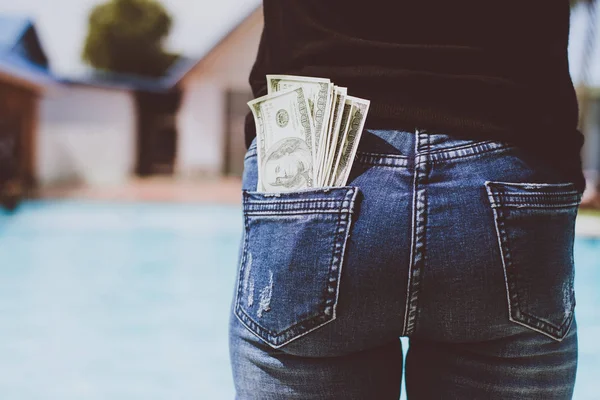 Woman with dollars money in her pocket.