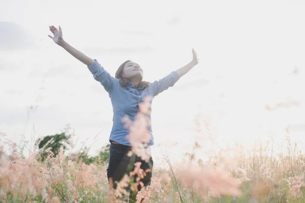 Jovem mulher feliz desfrutar no campo no pôr do sol . — Fotografia de Stock