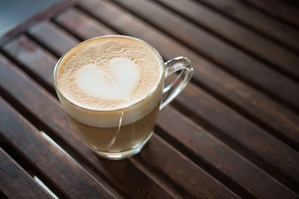Close up of cappuccino cup with heart shaped milk pattern at caf