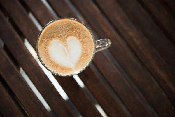Nahaufnahme einer Cappuccino-Tasse mit herzförmigem Milchmuster bei Caf — Stockfoto