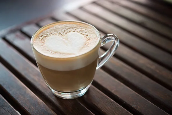 Close up de copo cappuccino com padrão de leite em forma de coração no caf — Fotografia de Stock