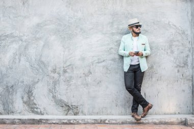 Smartphone karşı kullanan yakışıklı genç hipster adam portresi 