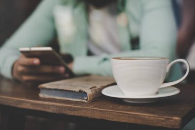 Onun smartphone, otururken kullanan yenilikçi genç yakışıklı adam