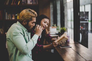 Hipster çift kapalı kitap okuma kafe otururken tatilde 