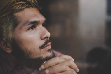 Kahve Dükkanı düşüncesinde ve lo oturan dalgın genç hipster adam