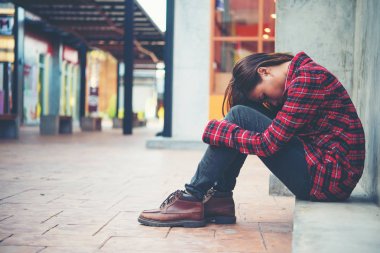 Grunge arka plan karşı katta oturan kadın üzgün.