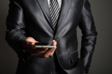 Genç işadamı cep telefonu siyah izole kullanarak.