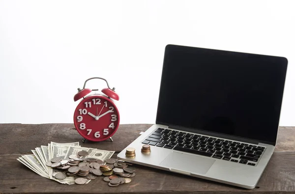 laptop with coins, alarm clock and dollar bank isolated on white