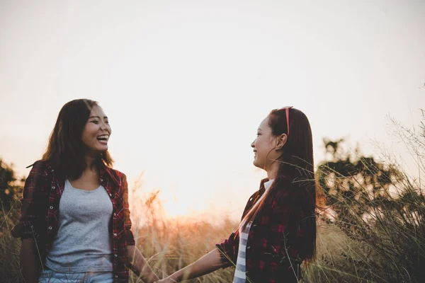 Avvicinamento di due ragazze. Amici intimi in campo con backgr tramonto — Foto Stock