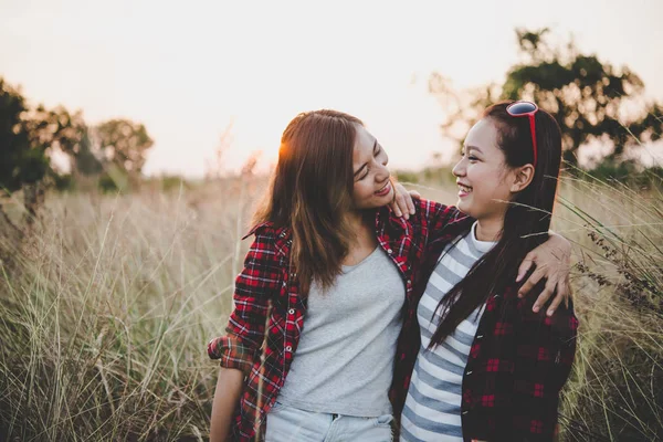 Avvicinamento di due ragazze. Amici intimi in campo con backgr tramonto — Foto Stock