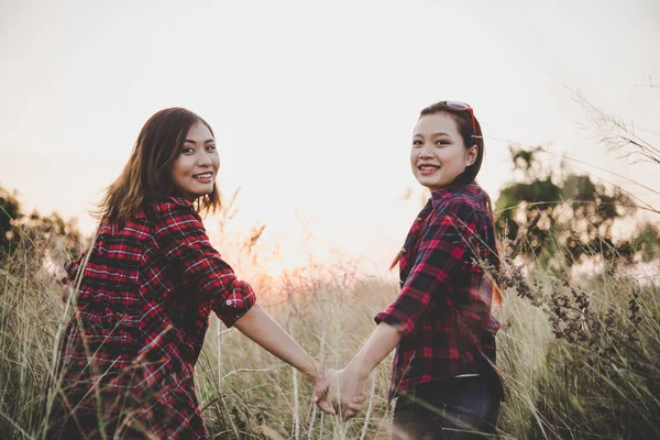 Närbild av två flickor. Nära vänner i fältet med sunset bakgr — Stockfoto