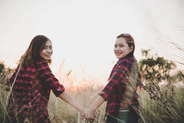 De perto de duas raparigas. Fechar amigos no campo com o pôr do sol backgr — Fotografia de Stock