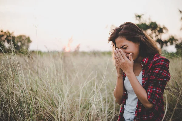 Close up van triest jonge vrouw in een veld. — Stockfoto