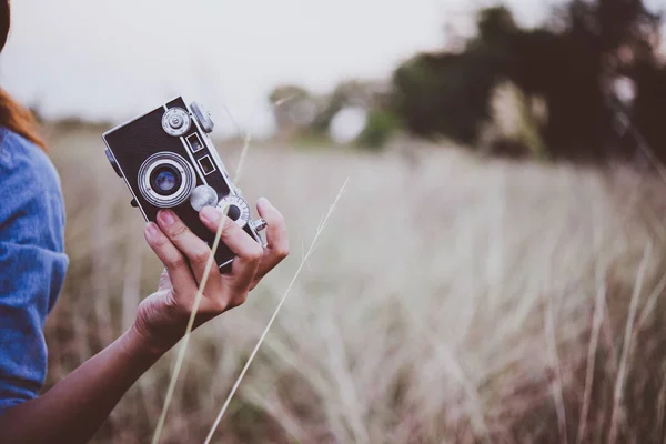 Mujer hipster joven feliz con cámara vintage en el campo. Disfrute de wi — Foto de Stock