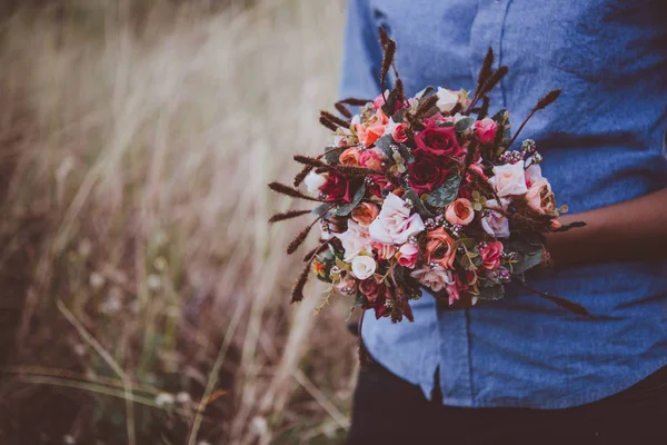 Junge Hipsterfrau im Feld mit einem Strauß roter Rosen, summ — Stockfoto